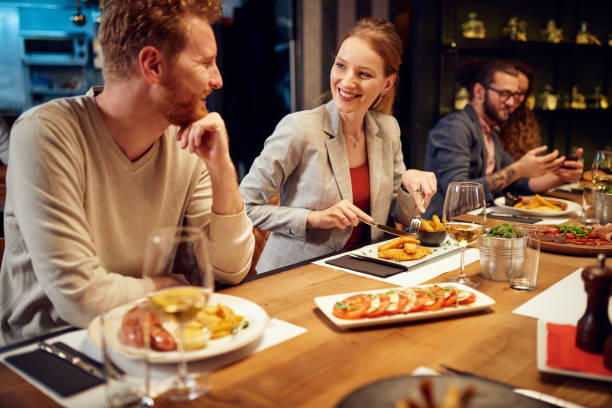 istock Group of friends sitting in restaurant and eating dinner. 1208870137