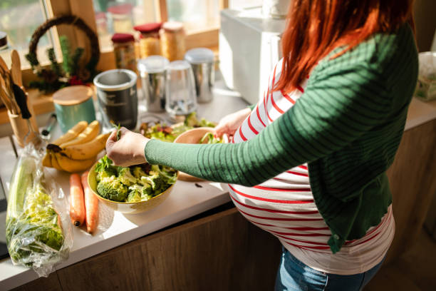 istock Cheerful modern woman preparing healthy salad for breakfast 1208871809