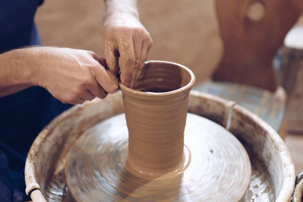 istock Potter making a vase on a potter's wheel 1208872155