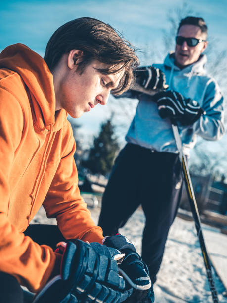 padre e hijo antes de la práctica de hockey - ice skating ice hockey child family fotografías e imágenes de stock