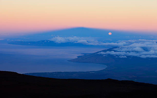 luna piena impostazione ombra del vulcano - sunrise maui hawaii islands haleakala national park foto e immagini stock