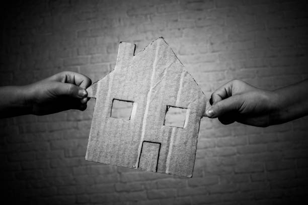 shooting in the Studio Children's hands hold a house cut out of cardboard. On the background of a white brick wall. tramp home stock pictures, royalty-free photos & images