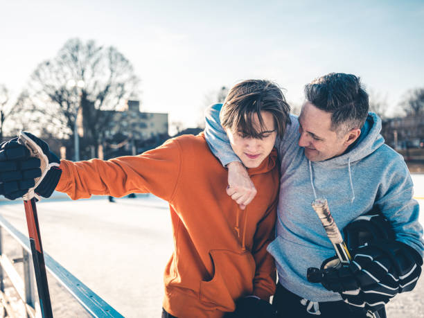 father and son playing hockey outdoors - ice skating ice hockey child family imagens e fotografias de stock