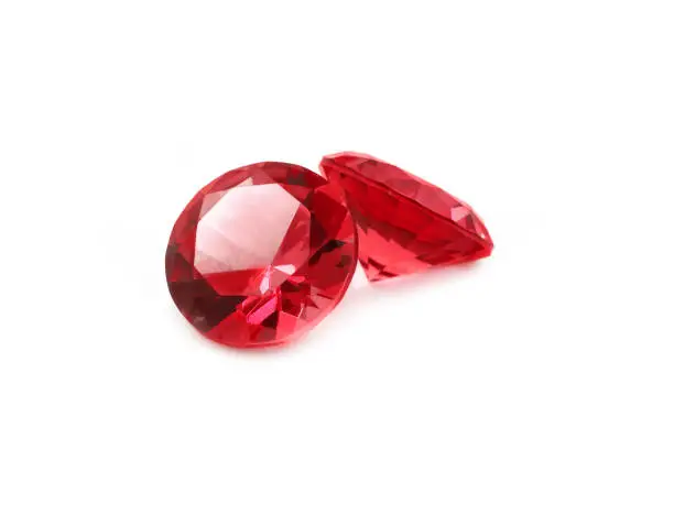 Beautiful faceted red gems on a white background.