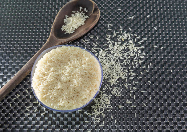 istock Peeled and processed grain rice on a dark background 1208876769