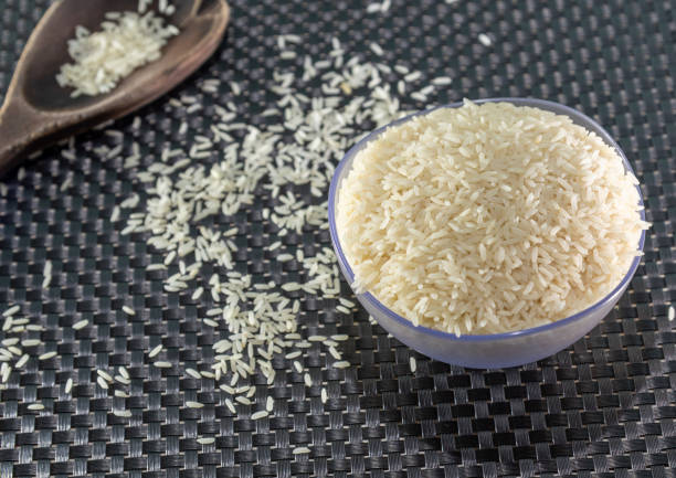 istock Peeled and processed grain rice on a dark background 1208876927