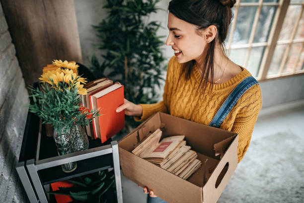 mujeres arreglando cosas en un apartamento nuevo - arranging fotografías e imágenes de stock