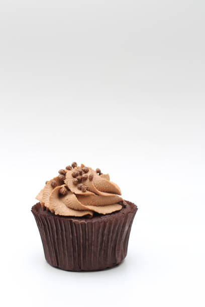 istock Isolated chocolate cupcake with cream top and crispy topping on a white background 1208880890