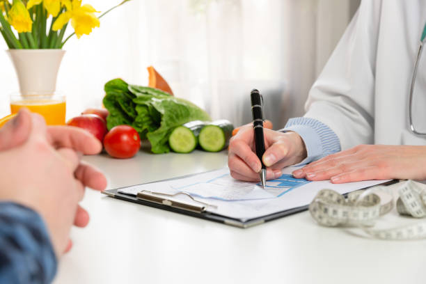 concepto de nutrición y medicamentos para la dieta vegetal. nutricionista ofrece una dieta saludable en vegetales. en una luz natural - prescription plan fotografías e imágenes de stock