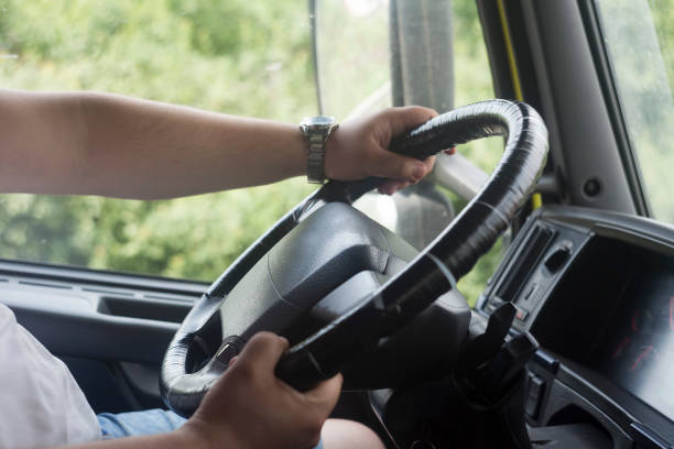 istock man with hands on truck steering wheel. 1208882118