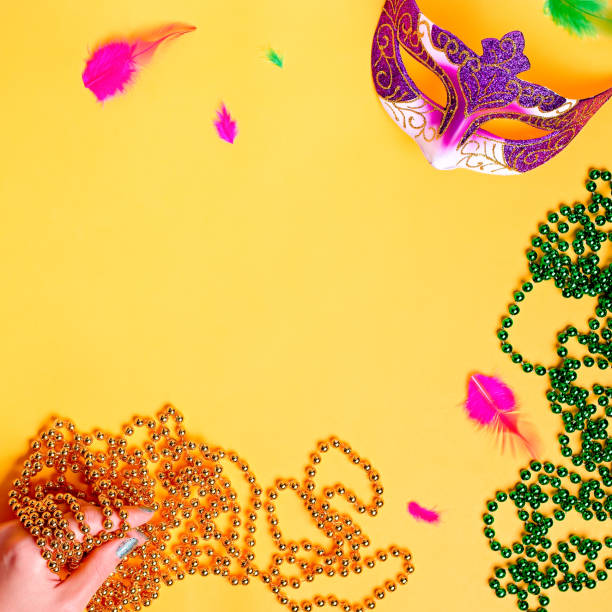 lila und grüne karnevalsmasken, federn und glänzende perlen, traditionelle karneval zubehör. mardi gras rahmen oder rand auf lila hintergrund, maskerade masken und perlen flach liegen, kopierraum, top-ansicht - 6729 stock-fotos und bilder