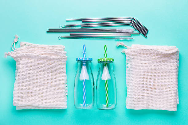 istock Glass jars, reusable straws for drink, mesh bags on blue table top. Flat lay zero wate concept or sustainable lifestyle. Plastic free background overhead 1208884014