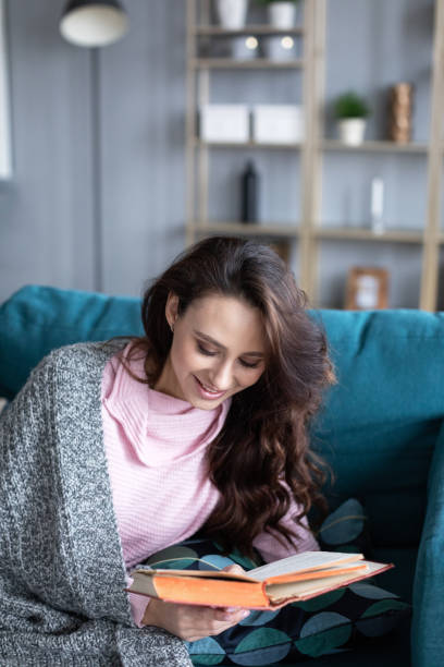 istock Happy young woman reading she holds book in hands. 1208884083