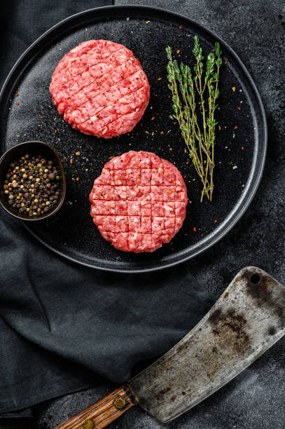 istock The ground beef patties, minced meat cutlets. Black background. Top view 1208887024