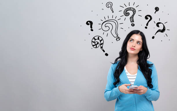 istock Question marks with woman holding a smartphone 1208892517