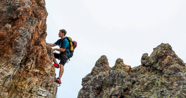 istock Young man climbs via ferrata ridge in the mist 1208898698