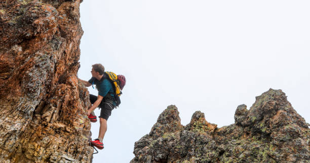 istock Young man climbs via ferrata ridge in the mist 1208898706