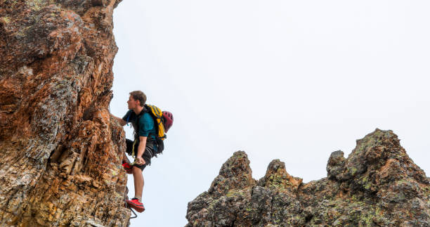 istock Young man climbs via ferrata ridge in the mist 1208898707