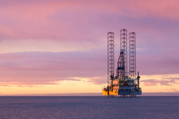 jackup oil platform at sunset - derrick crane drilling rig well sky imagens e fotografias de stock