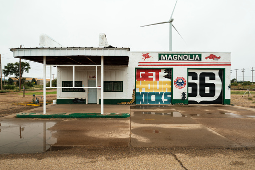 Tucumcari, New Mexico USA - October 4, 2019: Cityscape view of a vintage and closed Americana style Magnolia gasoline station with colorful signage along the historic Route Highway 66 that runs through this small rural town located in Quay County in northeast New Mexico.