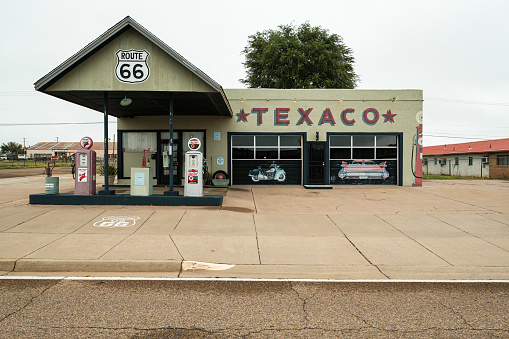 Tucumcari, New Mexico USA - October 4, 2019: Cityscape view of a vintage and closed Americana style Texaco gasoline station with colorful signage along the historic Route Highway 66 that runs through this small rural town located in Quay County in northeast New Mexico.