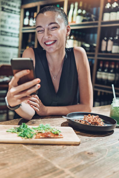 istock Young businesswoman with cell phone in a restaurant 1208904459