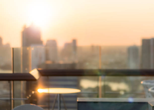 istock Blur abstract background city morning gold light sky rooftop view over cityscape with bright sun flare and bokeh 1208909038