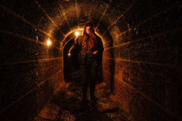 istock Urban explorer with candle in old vaulted underground tunnel 1208911742
