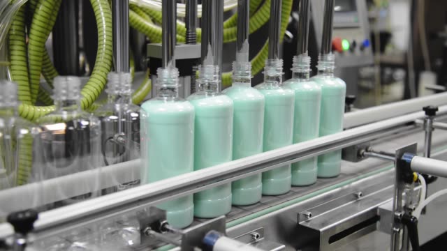 Conveyor of the production line with filling of transparent plastic bottles at the factory