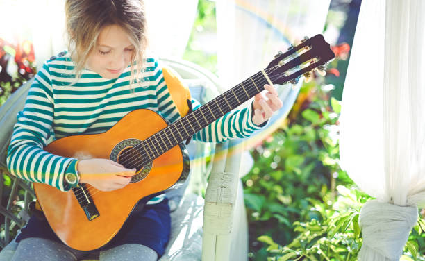 istock Child practicing the guitar on the front porch 1208935666