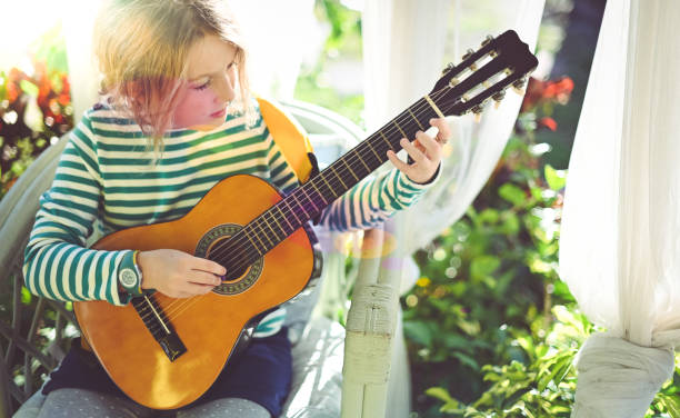 istock Child practicing the guitar on the front porch 1208935828