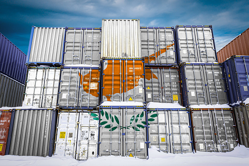 The national flag of Cyprus
 on a large number of metal containers for storing goods stacked in rows on top of each other. Conception of storage of goods by importers, exporters