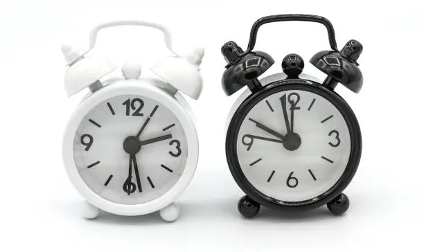 Photo of Black and White retro alarm clock isolated on white background.
