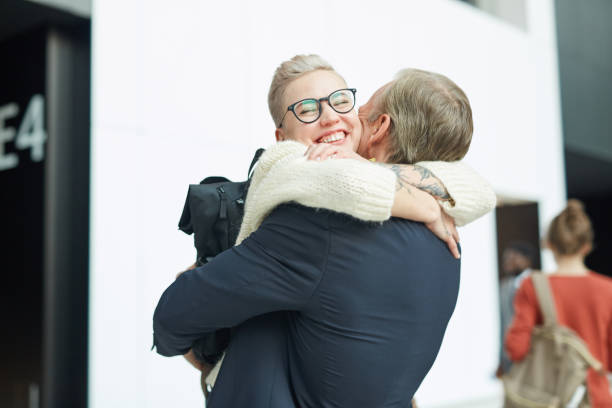 Happy young woman hugging her loving father, she has not seen for a long time, in airport, copy space