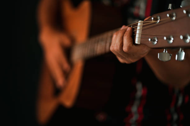 istock Close up guy's hand playing guitar. 1208953571