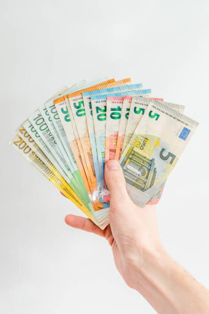 istock Human hand hold EUR banknotes. Euro bills on reverse side held in hand. 1208954897