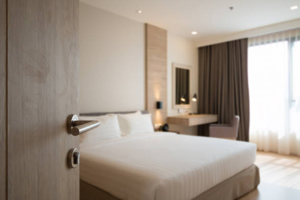 door opened to bedroom Opening the door handle to the cozy main bedroom with king size bed and working desk with mirror at the room corner. thai door stock pictures, royalty-free photos & images