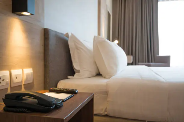 Closeup on telephone on side desk  in the modern hotel bedroom.