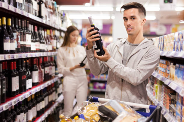 istock Young man buying bottle of wine 1208960883