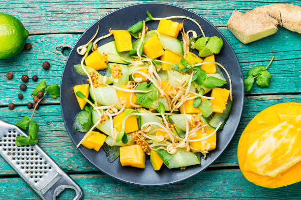 Salad with mango and vegetables. Spring salad with mango, cucumber and sprouts.Vegetable salad of sprouted mung beans salad fruit lettuce spring stock pictures, royalty-free photos & images