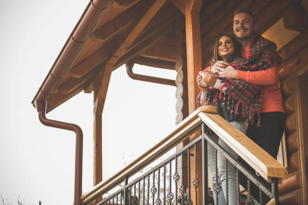 istock Low angle view of young couple cuddling on a patio while waiting for someone 1208965738