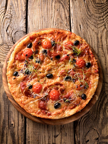 istock Delicious pizza served on wooden plate 1208971166