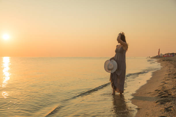 istock Young Woman Enjoys Morning Walk at the Beach 1208972105