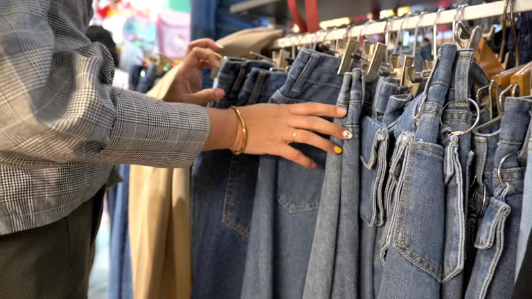 Scene slow motion of asian young woman shopping for jeans in clothing store, Concept of holiday end of week, Lifestyle of asian woman