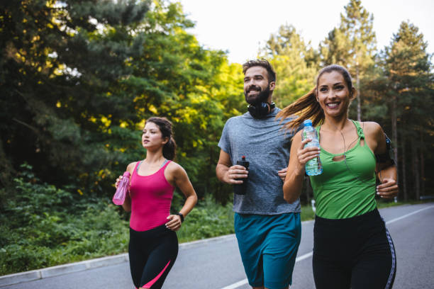 istock Three young people jogging together in nature 1208976234