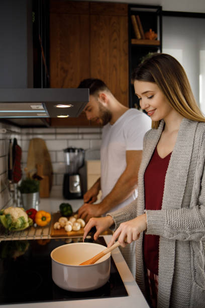 istock Young romantic couple cooking in the kitchen together 1208977333
