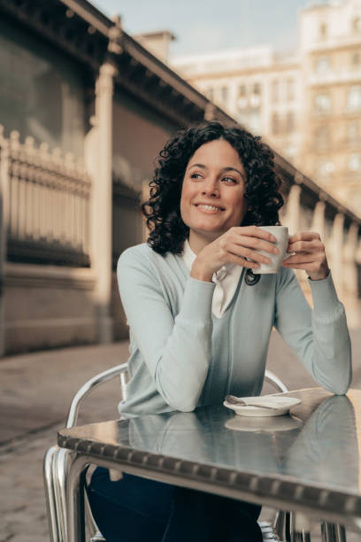 istock Smiling woman holding a coffee cup 1208978174