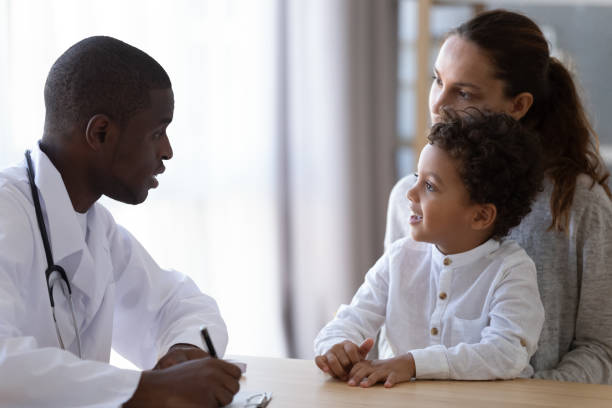 young african american male pediatrician listening to little patient complaints. - child little boys male caucasian imagens e fotografias de stock