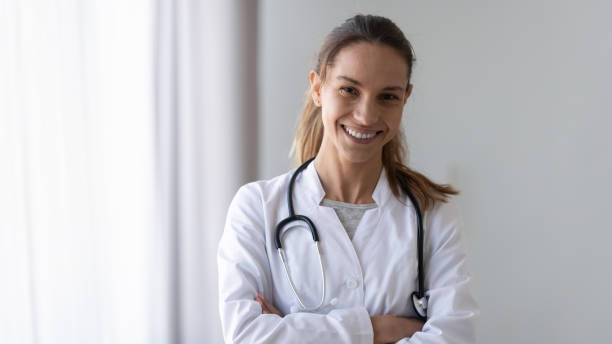 istock Smiling friendly young female professional confident doctor head shot. 1208979531