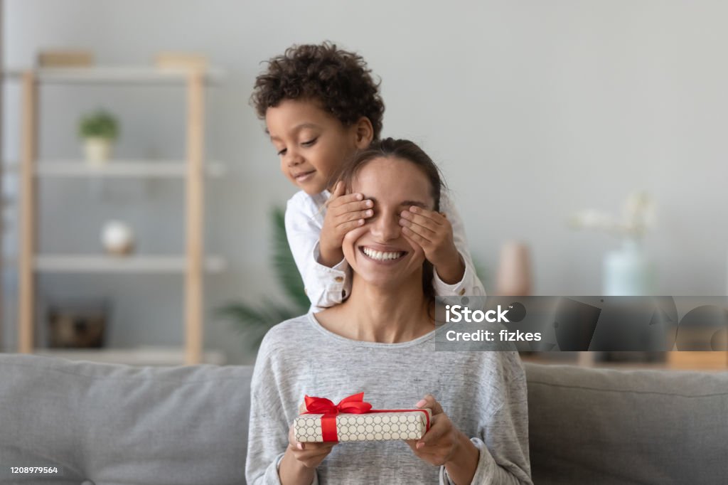 Happy excited woman sitting on couch with covered eyes. - Royalty-free Mãe Foto de stock